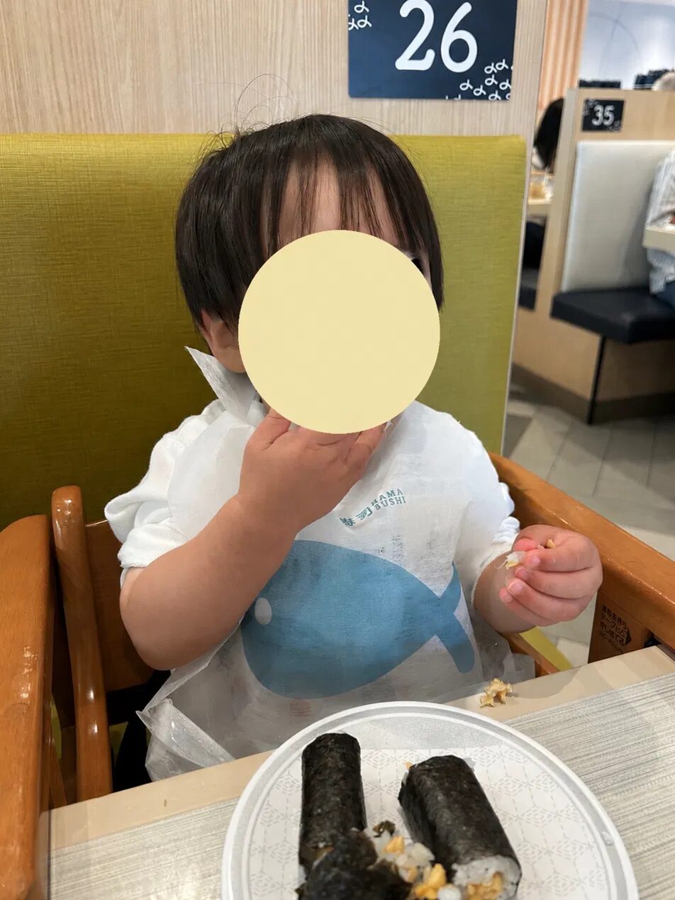 はま寿司のキッズチェアに座って納豆巻きを食べる2歳の子ども
